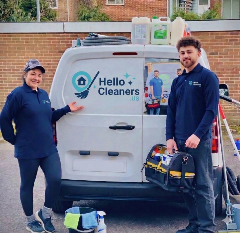 Two Hello Cleaners cleaners loading cleaning supplies and equipment at the back of a branded van
