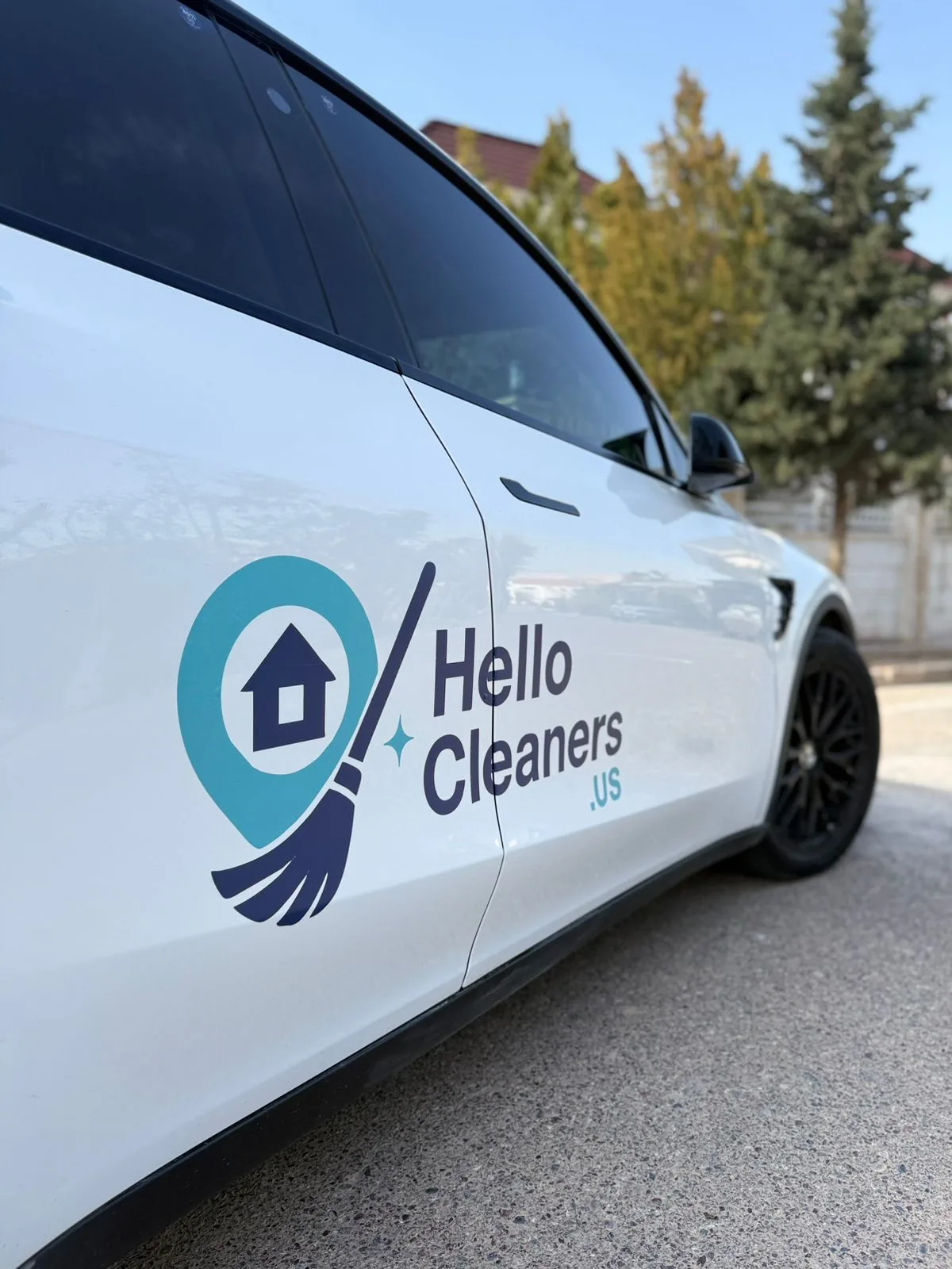 The Hello Cleaners logo on the door of a white branded Hello Cleaners vehicle