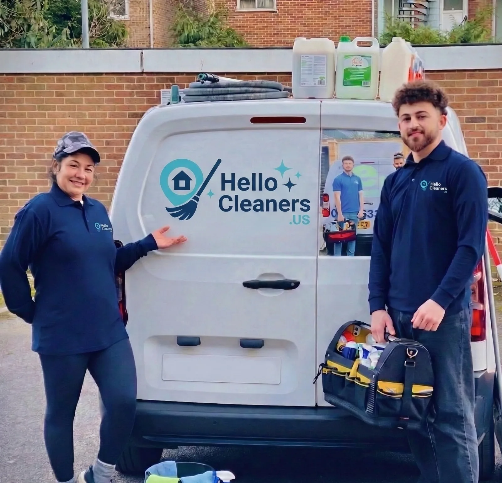 Two Hello Cleaners team members beside a branded Hello Cleaners service van with their cleaning kit